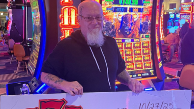 A picture of a Guest who won a jackpot holding up a big check!