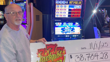 A picture of a Guest who won a jackpot holding up a big check!