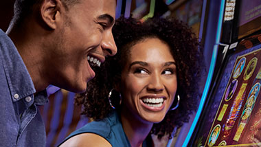 two people cheering at slot machine