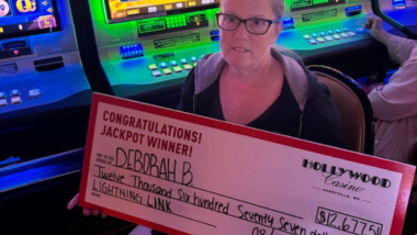 Jackpot Winner holding a big check for 12,000 dollars