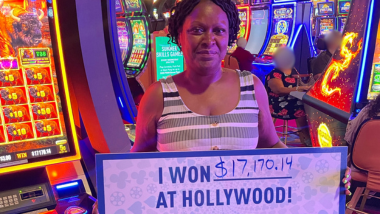 A woman holding a sign saying I Won $17,170 at Hollywood!