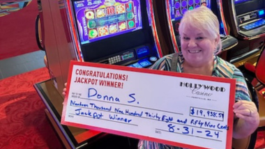 Donna S. holding a big check with the amount of money she won!