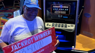 A PENN Hero holding a jackpot winner sign for $13,500!
