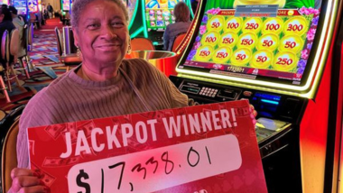 Woman smiling and holding a sign that says she won a $17,338 jackpot!