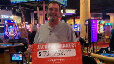The Guest holding a Jackpot Winner sign displaying the $71,758 that he won.