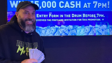 Picture of a winner holding a fan of cash.