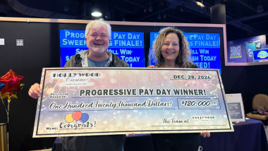 James and Hollywood Casino Perryville General Manager Amy holding a big check and smiling.