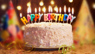 birthday cake with candles spelling out "HAPPY BIRTHDAY"