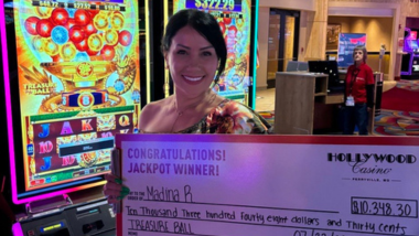 Guest holding up a giant check with the amount they won on it.