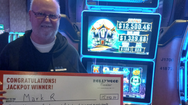 man holding up a big check that says how much he won!